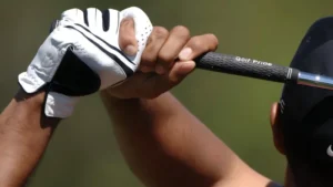 Golfer wearing custom white and black golf gloves in a backswing position